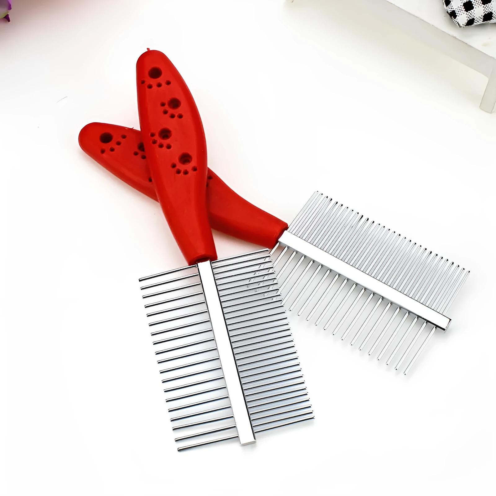 Double-row pet grooming comb with red handle and stainless steel needles on white background