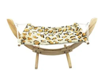 Cat hammock wooden bed with beige removable cushion on a radiator, providing a cosy perch for cats.