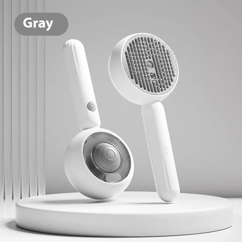 Grey and brown pet spray comb with stainless steel teeth and one-click mechanism on white background