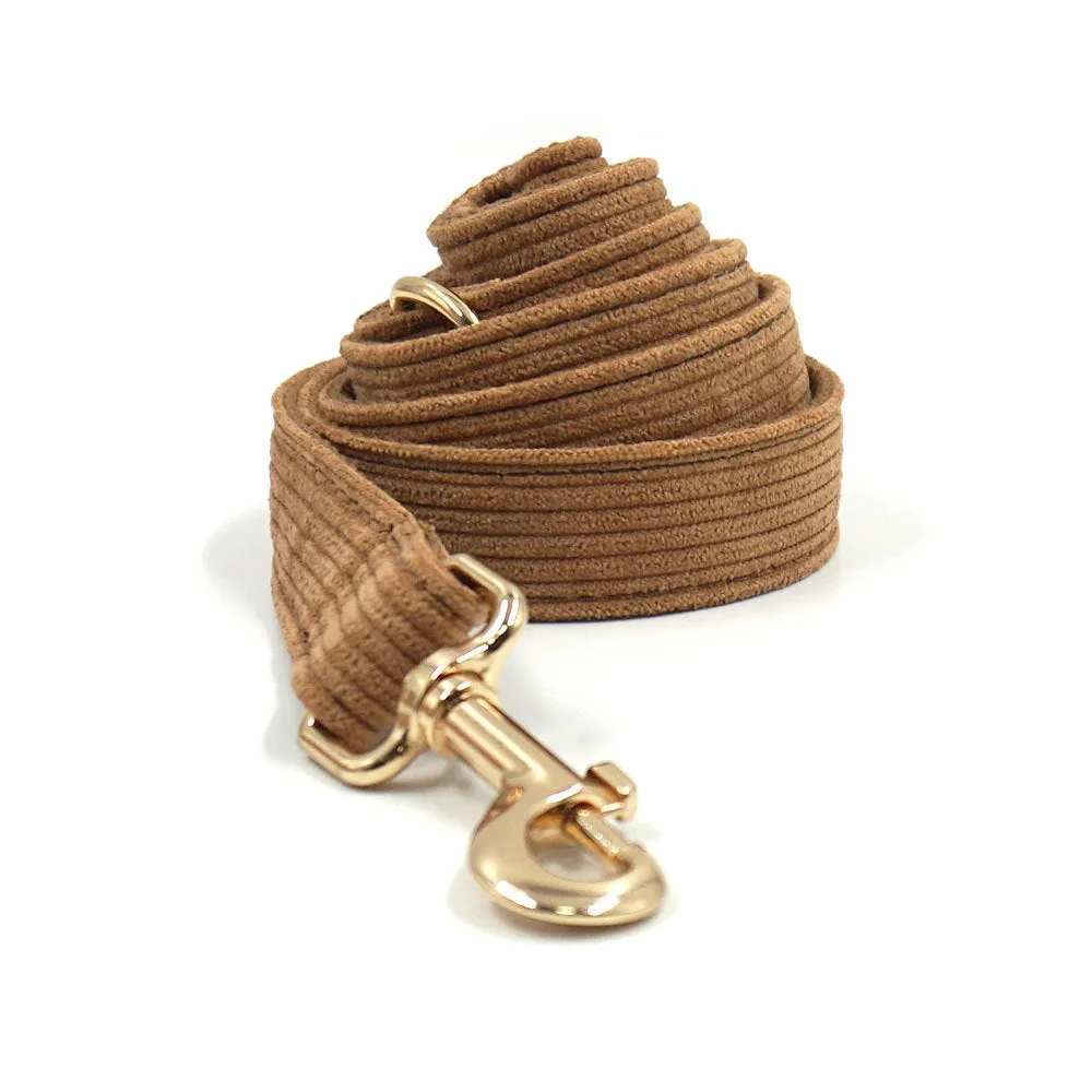 Brown corduroy dog collar and harness set with gold buckle and matching bow on a white background