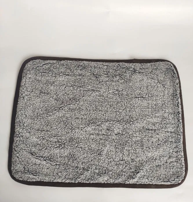 Waterproof urine proof pet blanket in grey with black and white bottom on a kennel bed