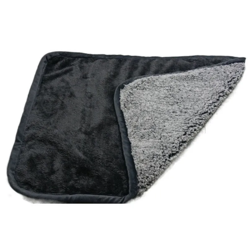Waterproof urine proof pet blanket in grey with black and white bottom on a kennel bed