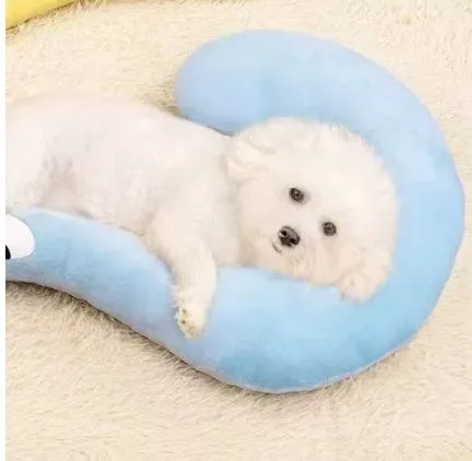 Blue U-shaped cat sleeping mat with integrated moon-shaped neck pillow on a wooden floor.