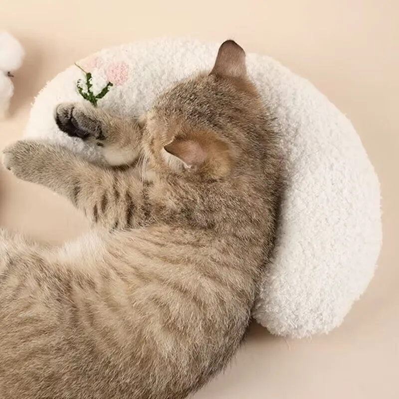 Blue U-shaped cat sleeping mat with integrated moon-shaped neck pillow on a wooden floor.