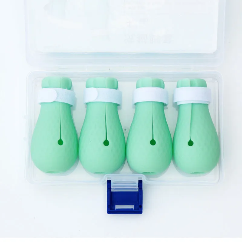 Set of four green silicone cat anti-scratch foot covers or gloves for pet care.