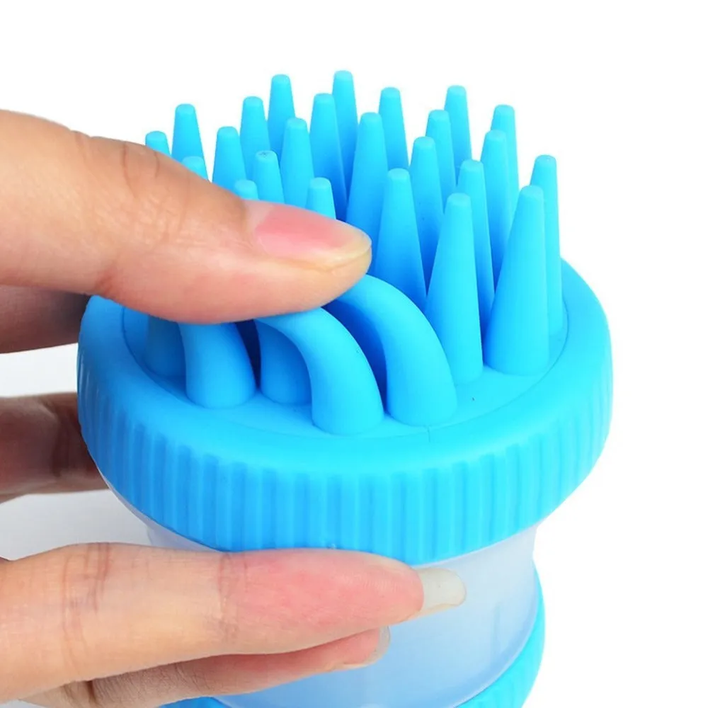 Silicone dog washing brush with built-in shampoo reservoir in blue on a white background