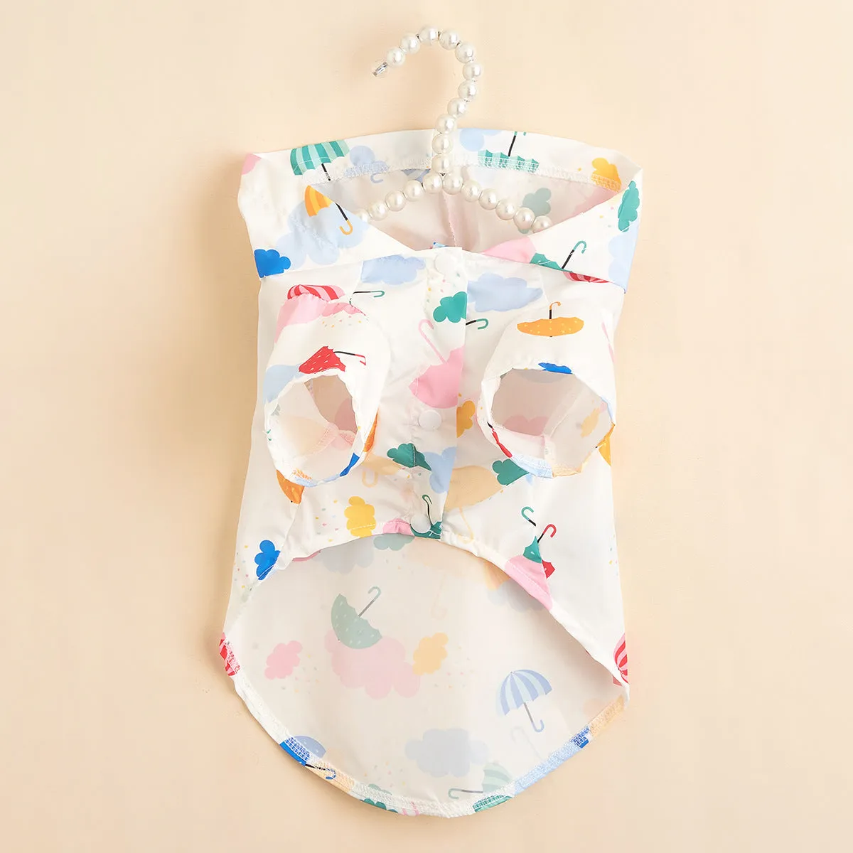 Colourful cartoon umbrella print dog raincoat in polyester, showing sizes XS, S, M, L, XL.