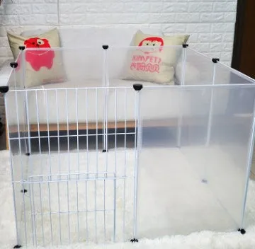 Pet transparent fence with six clear plastic panels arranged as a barrier on a wooden floor, showing interlocking connectors