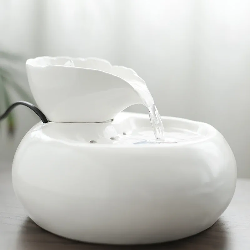 White porcelain leaf-shaped automatic cat water dispenser on floor