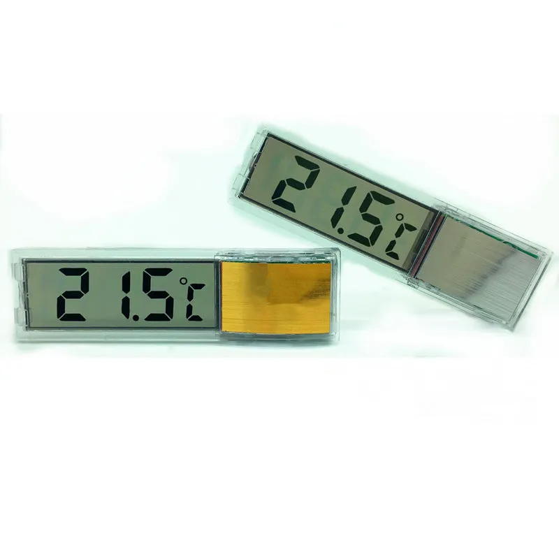 Gold digital thermometer mounted on aquarium glass showing temperature reading