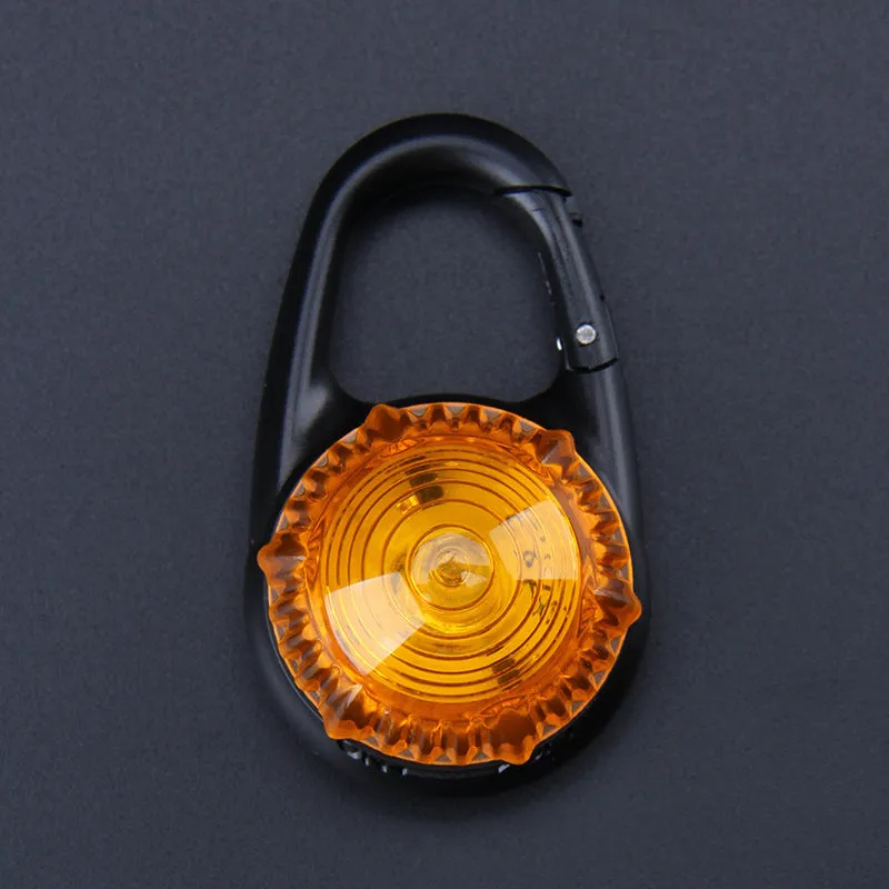 Pink LED flashing pet safety pendant clipped onto a collar with CR2032 batteries, showing 57x33mm ABS water-resistant build