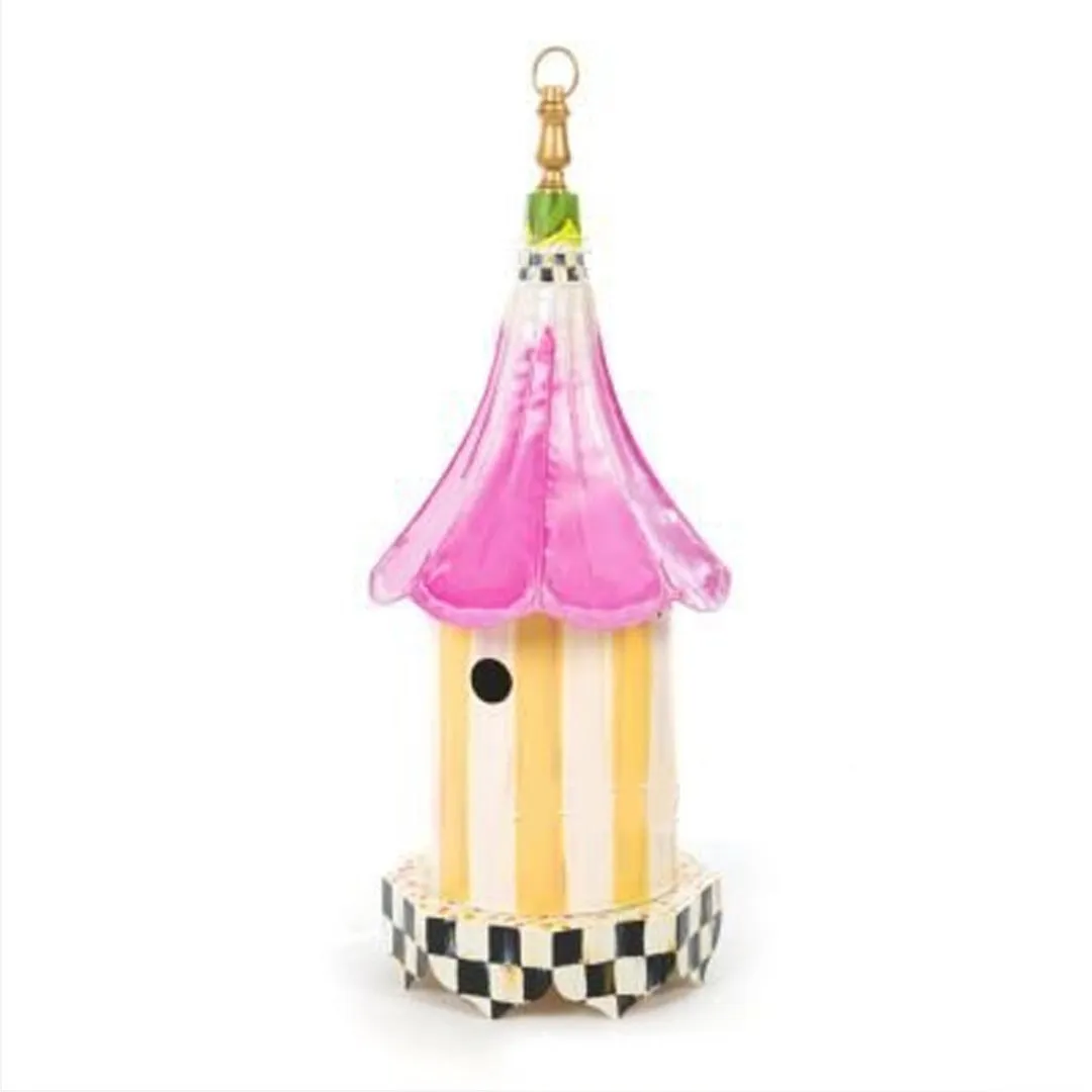 Iron metal bird feeder with creative pattern hanging from tree branch in garden