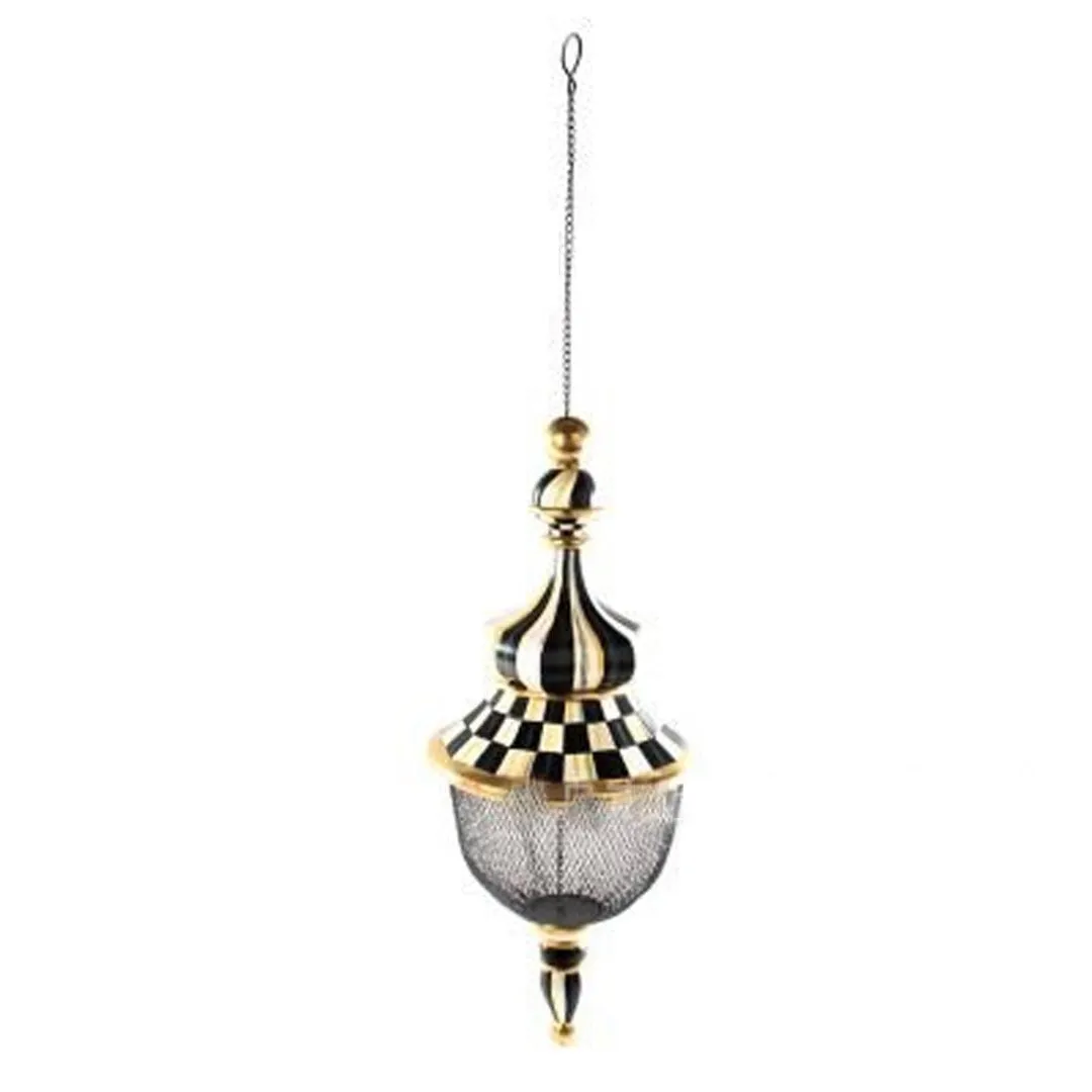 Iron metal bird feeder with creative pattern hanging from tree branch in garden