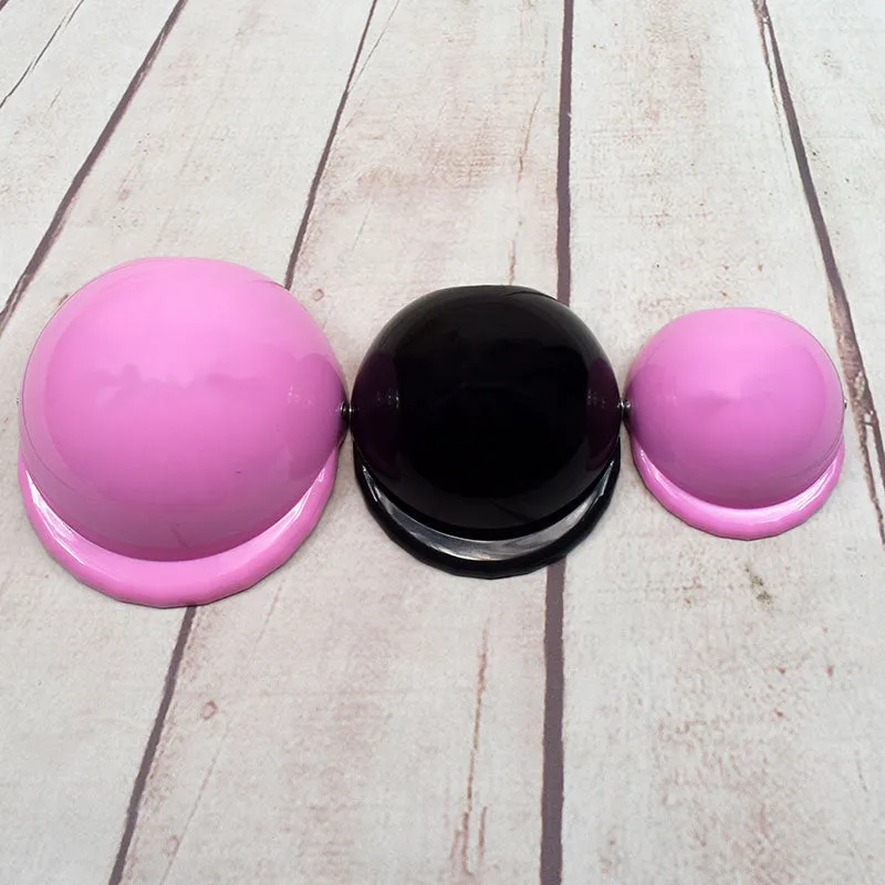 A pink plastic dog hat designed like a motorcycle helmet on a white background.
