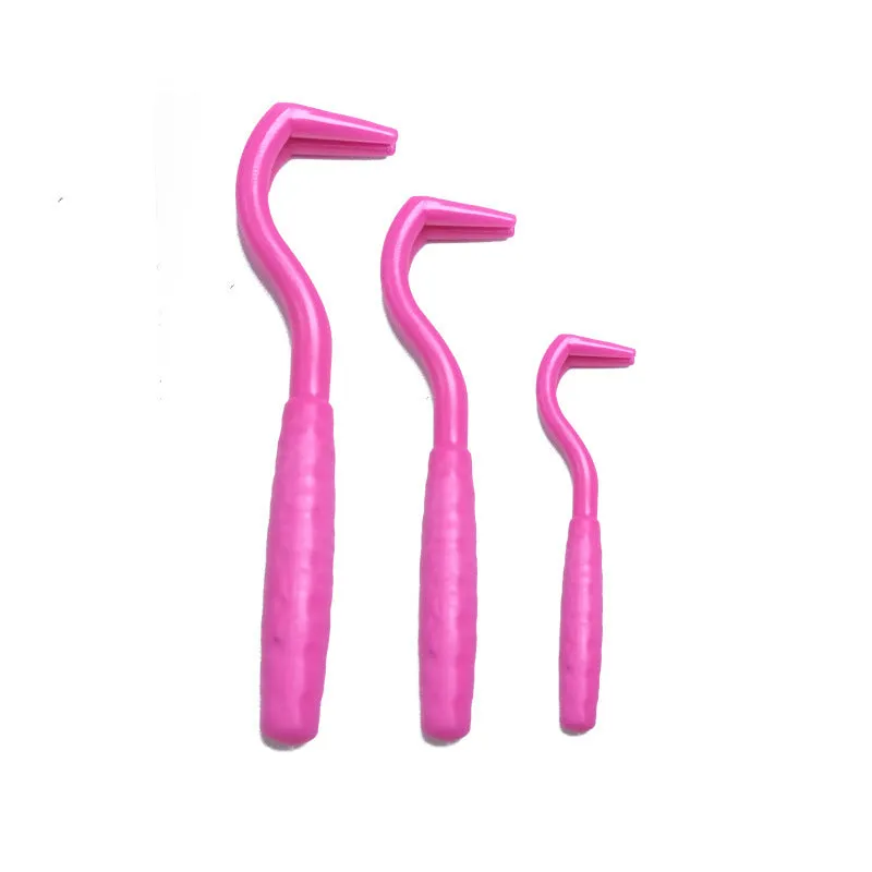Set of three coloured plastic tick removal hooks for dogs on a white background.