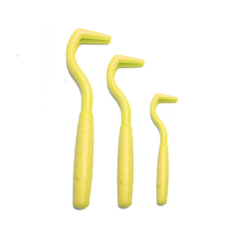Set of three coloured plastic tick removal hooks for dogs on a white background.
