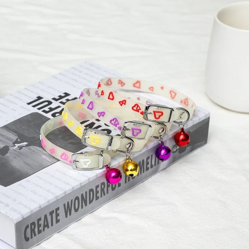 Silicone light-up cat collar with luminous fish bone and heart patterns on a pink background