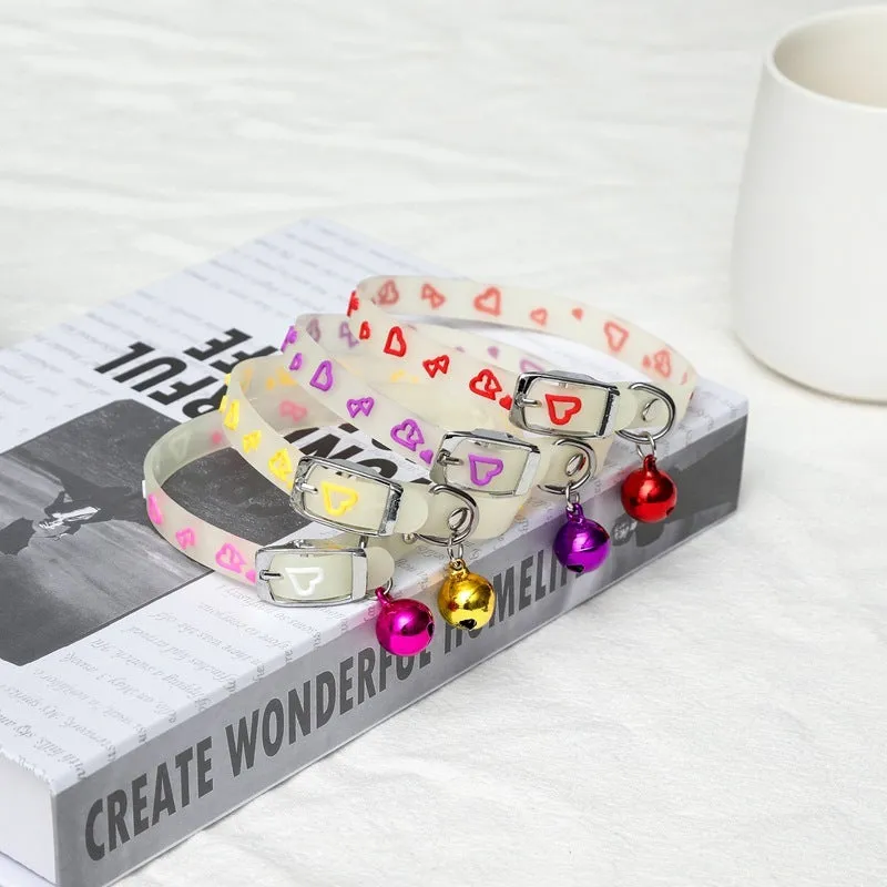 Silicone light-up cat collar with luminous fish bone and heart patterns on a pink background
