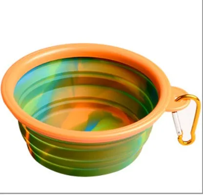 Collapsible silicone dog bowl in camouflage pattern folded flat on green surface