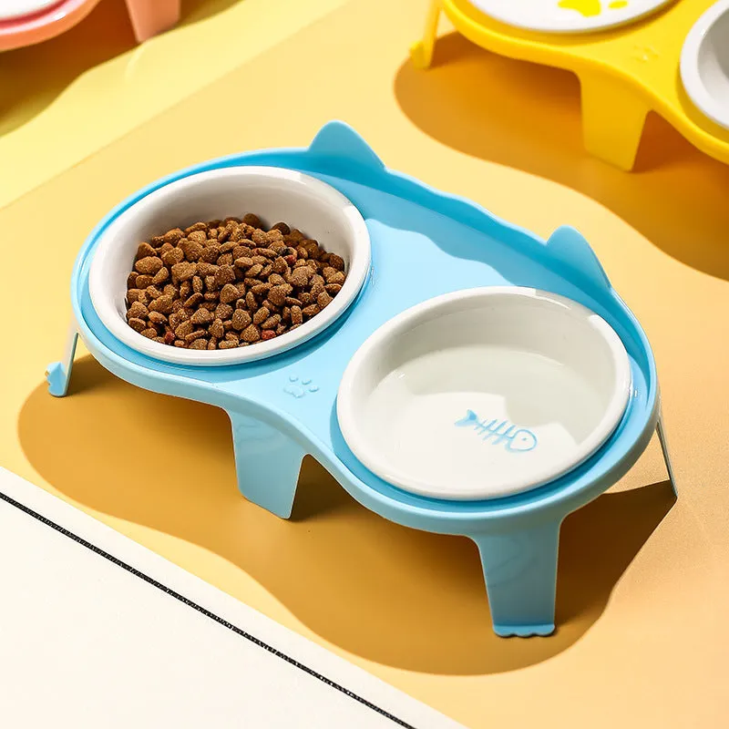 Blue ceramic cat food and water bowls in a white elevated plastic stand with a hook.