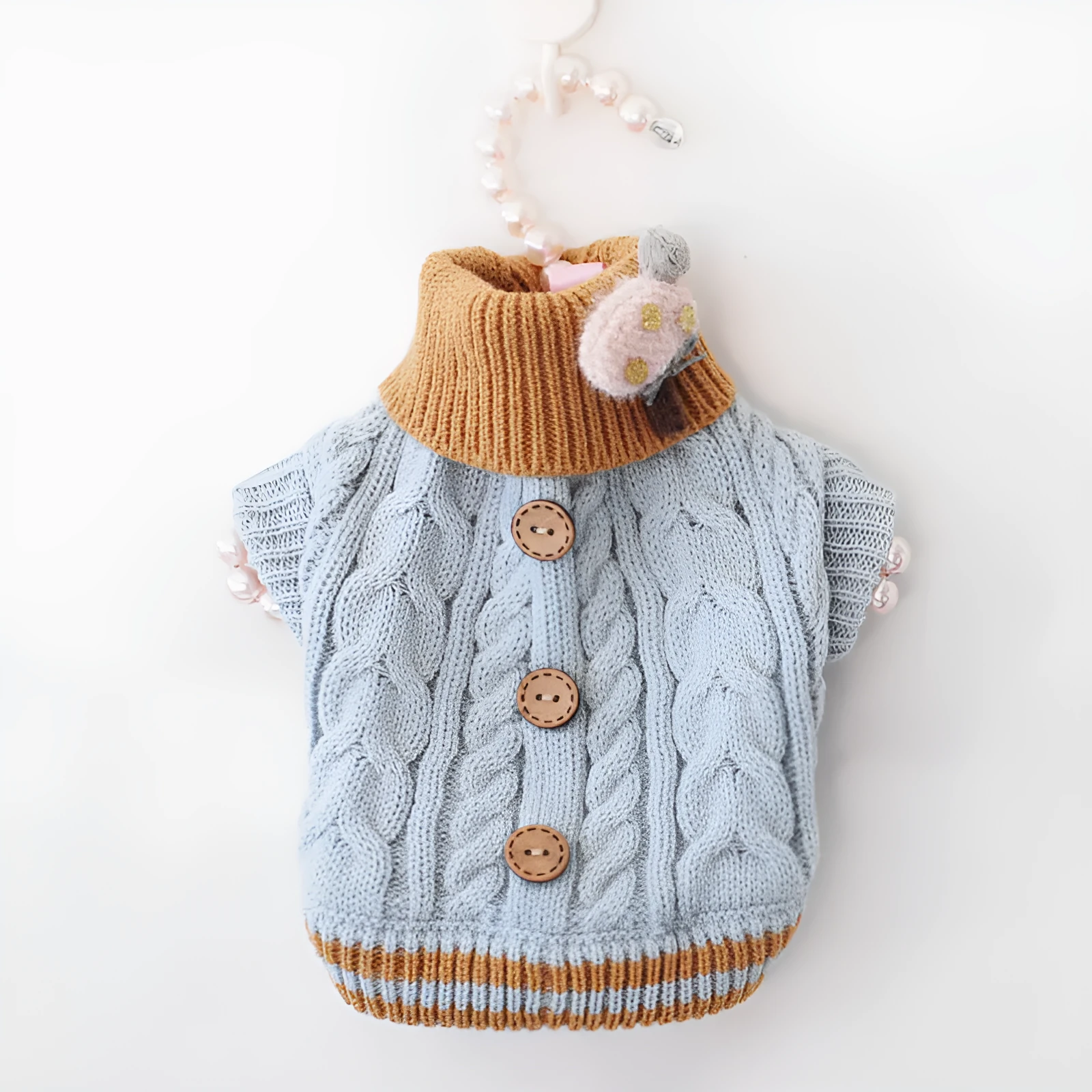 Classic knitted pet sweater in pink for small dogs, with twist button closure, on a white background