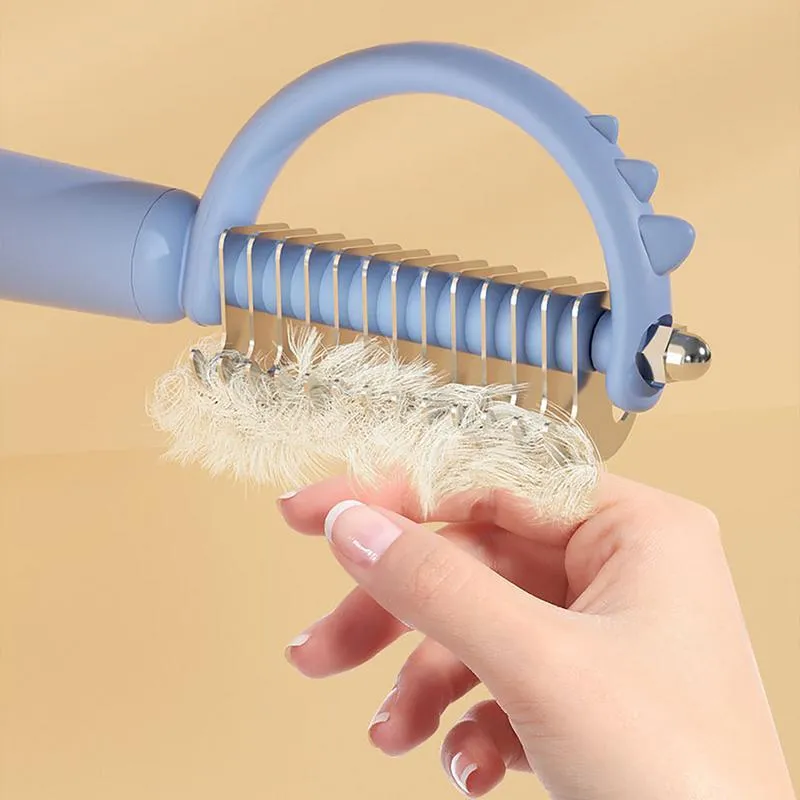 Dinosaur-shaped double-sided cat brush with self-cleaning mechanism in blue, green and white colours