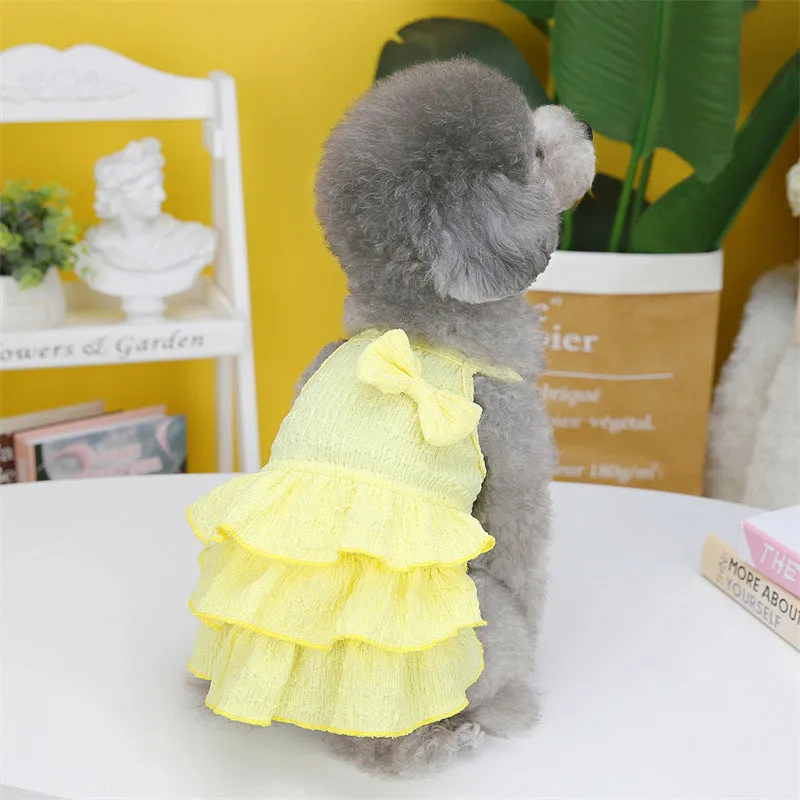 Small dog wearing a rose red princess dress with a layered candy skirt.