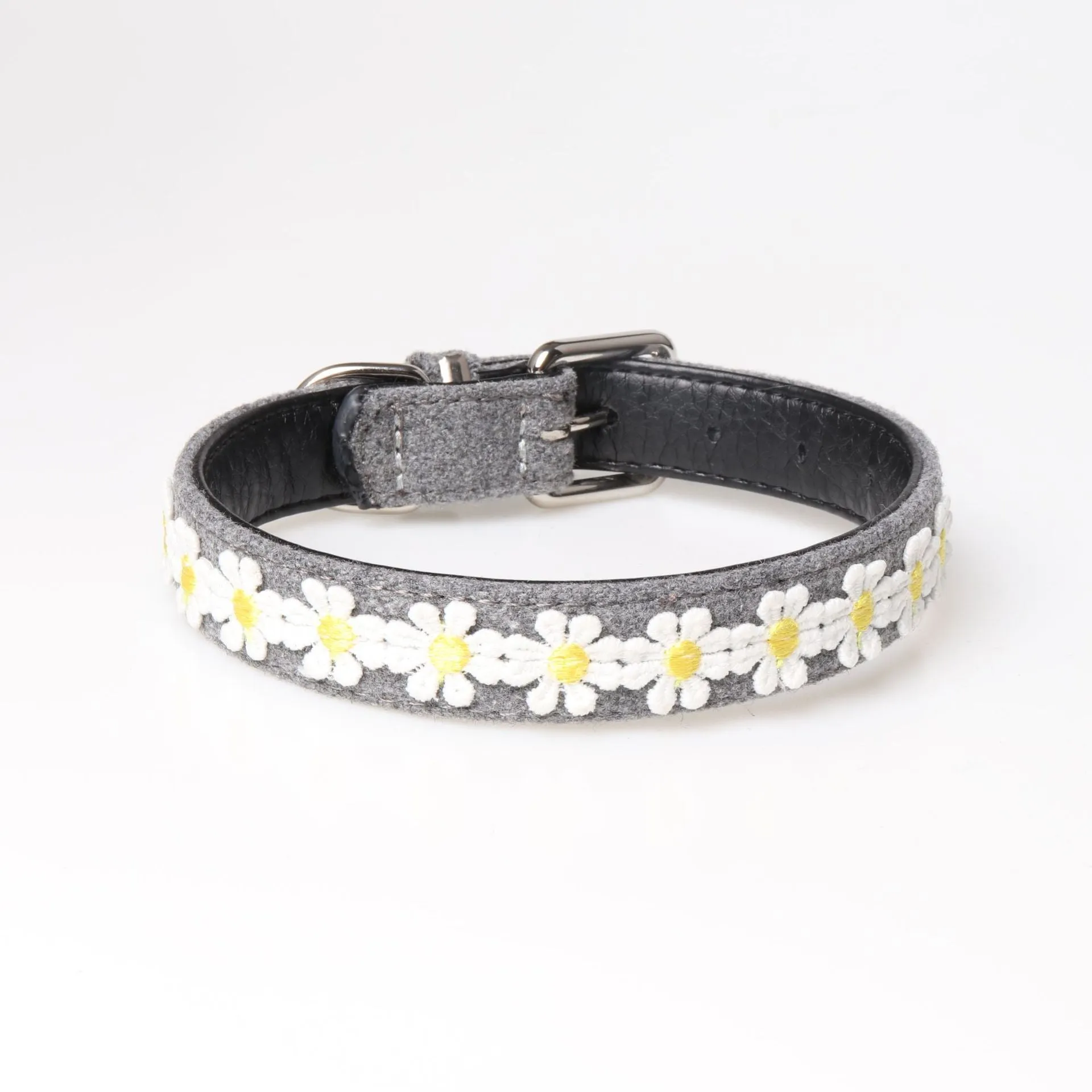 Embroidered PU dog collar with metal buckle on a neutral background, available in four colours and two adjustable sizes