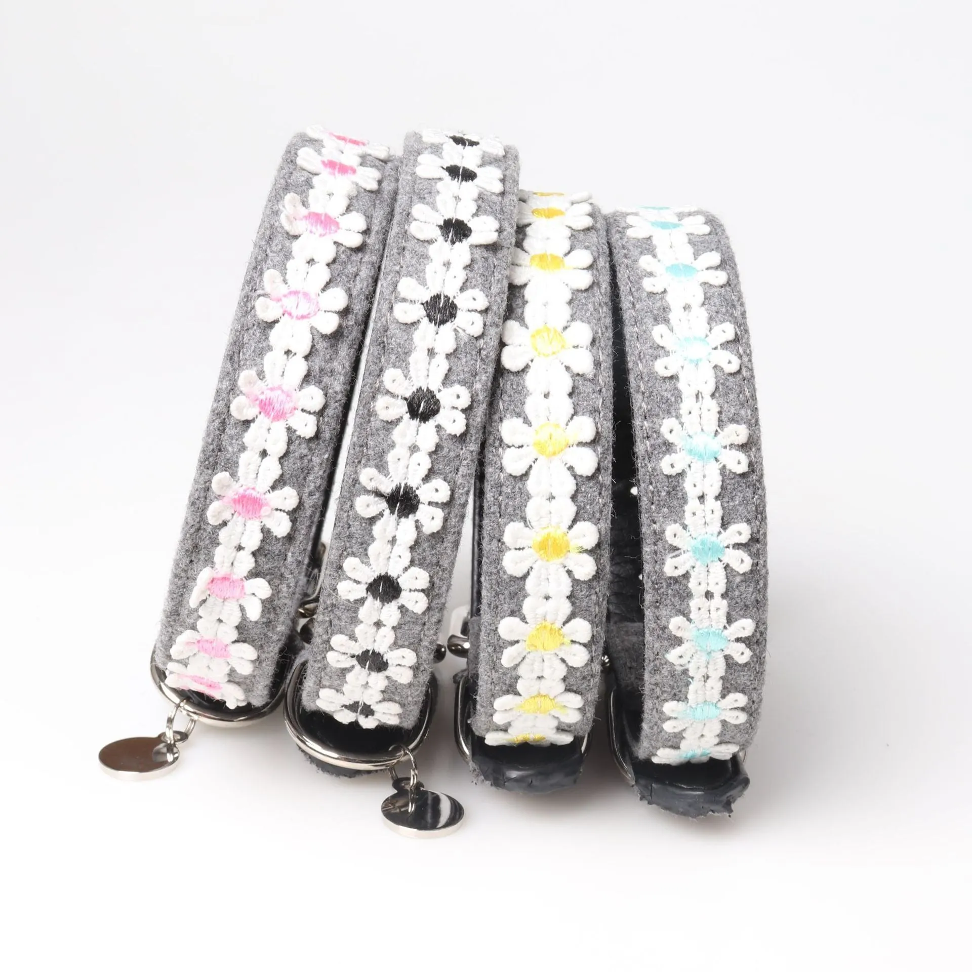 Embroidered PU dog collar with metal buckle on a neutral background, available in four colours and two adjustable sizes