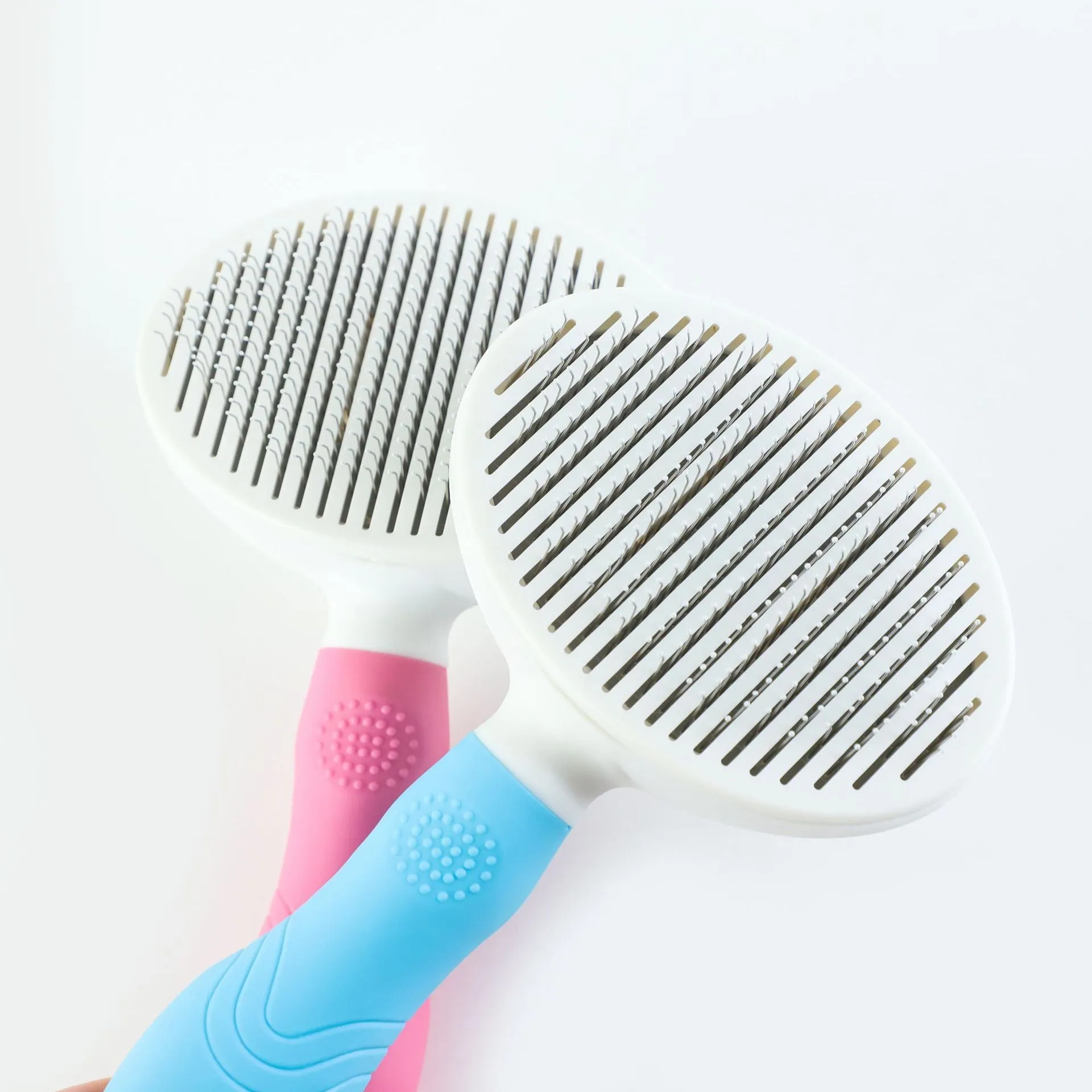 Blue automatic hair removal pet comb with TPR non-slip grip and button shaved design on white background