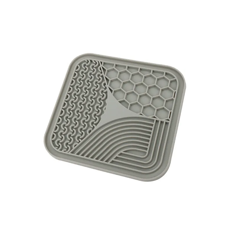 Gray silicone anti-choke slow feeding dog licking pad with textured surface on a flat surface