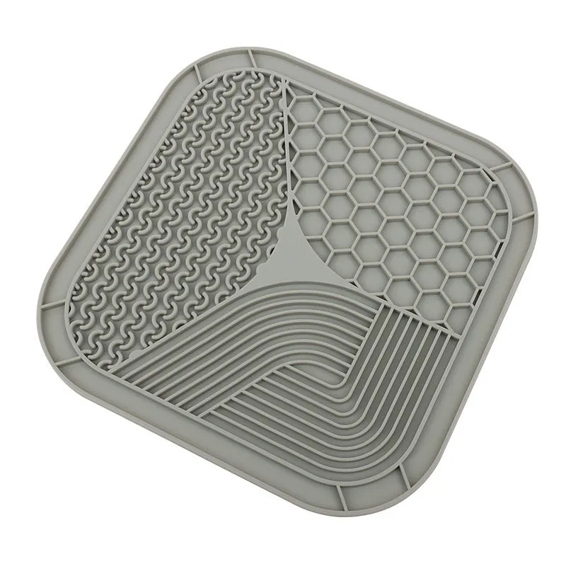 Gray silicone anti-choke slow feeding dog licking pad with textured surface on a flat surface
