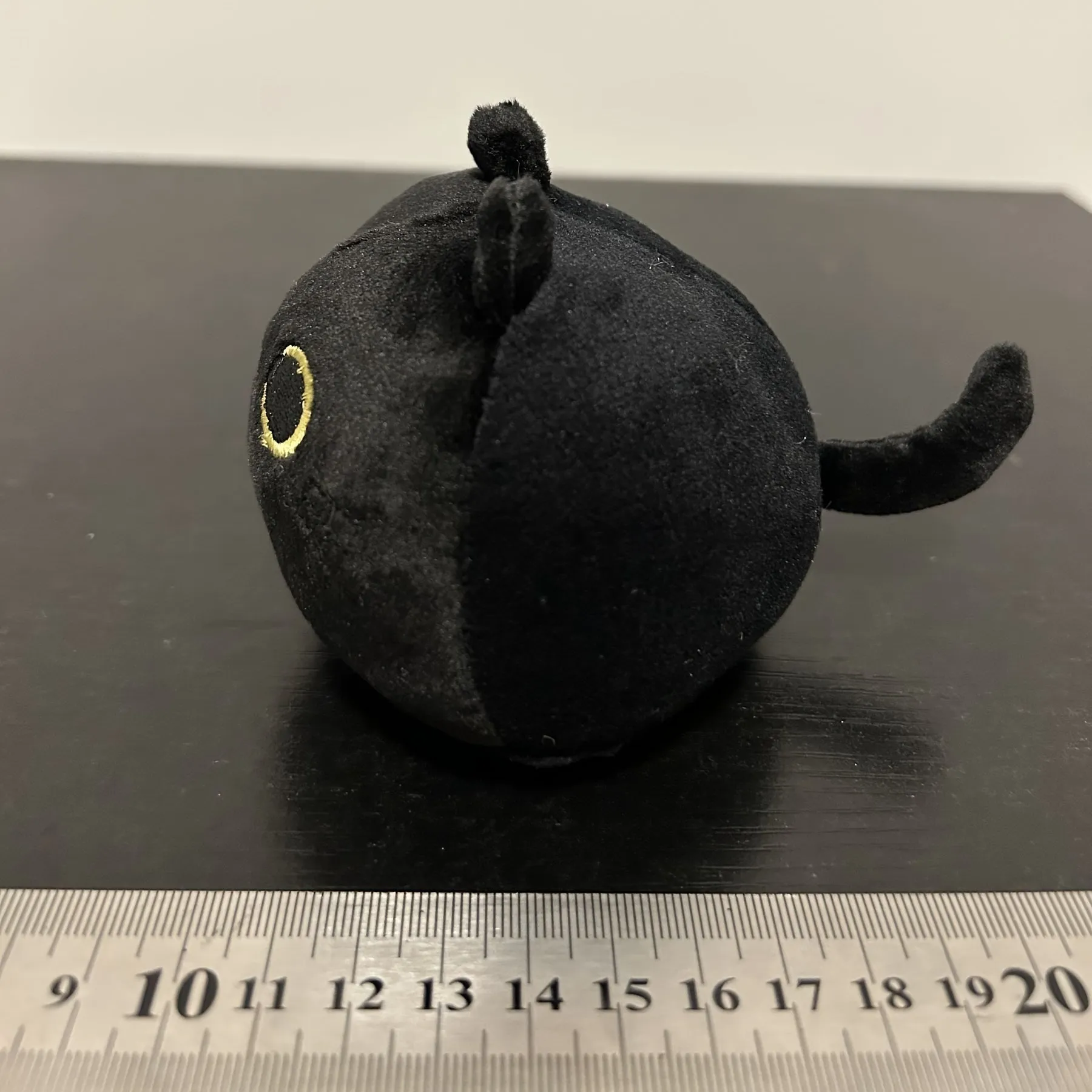 Fluffy black cat plush toy stuffed animal pillow cushion on a neutral background