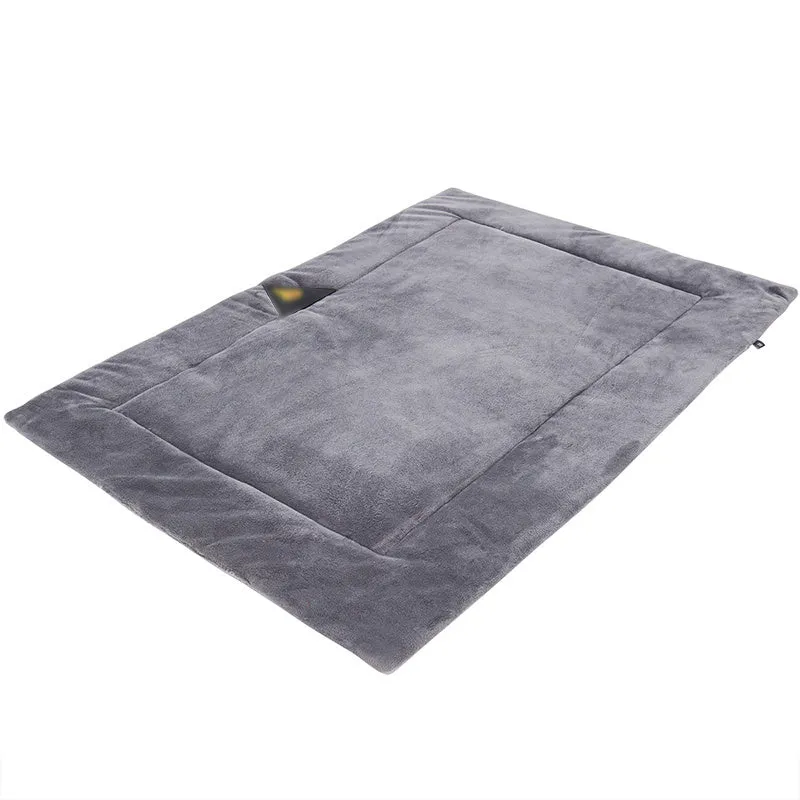 Self-heating pet mat in brown with soft fleece surface and non-slip base on wooden floor