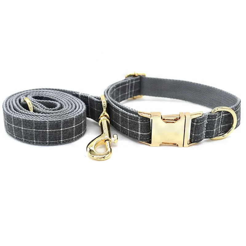 Grey plaid nylon dog collar with golden metal button on a white background, size M shown