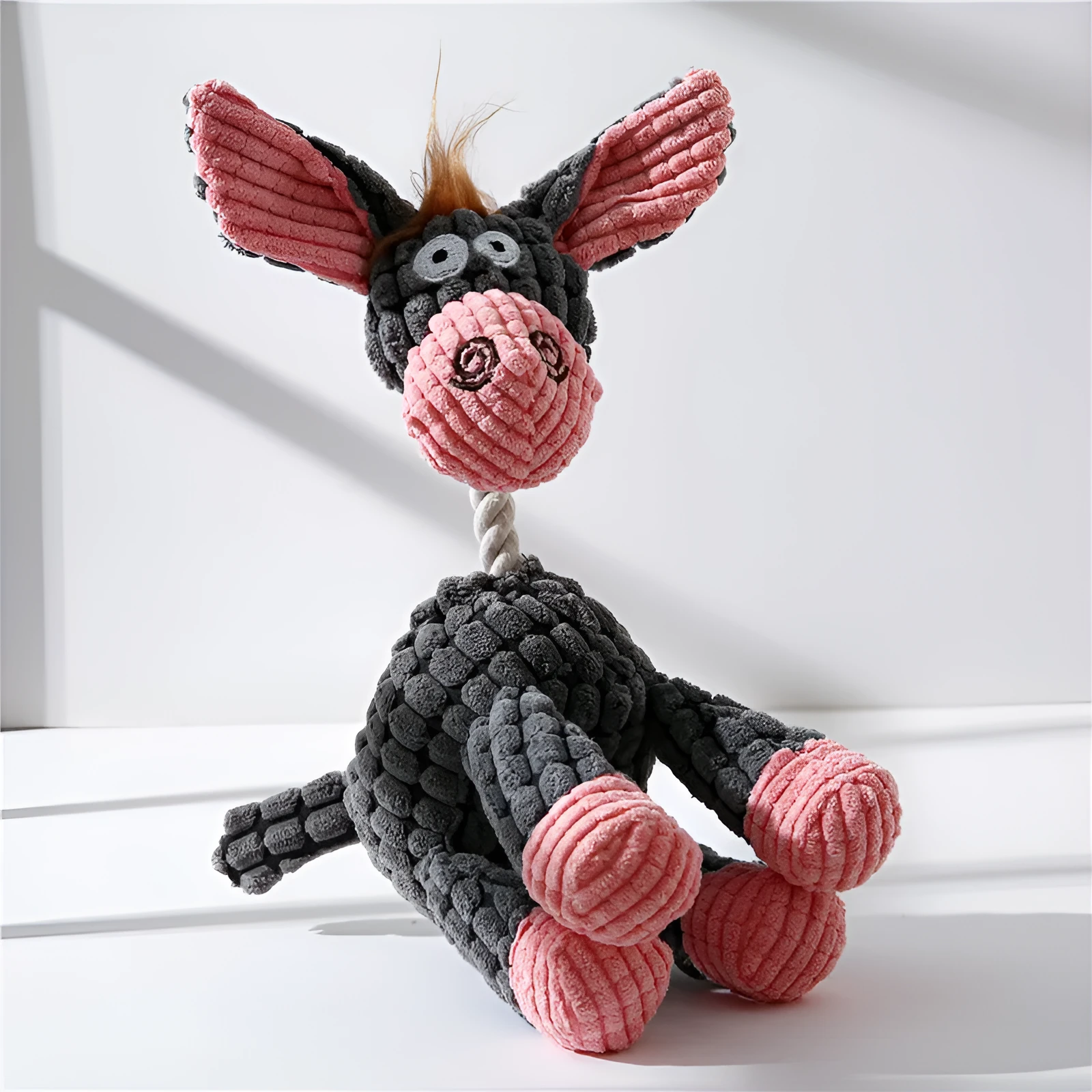 Pink donkey plush dog toy with scrunch and squeak features for interactive play