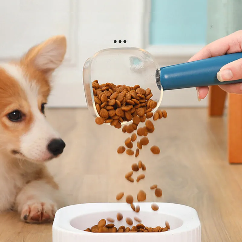 Transparent plastic pet food spoon with scale markings for measuring cat and dog dry food, available in Blue Pink White