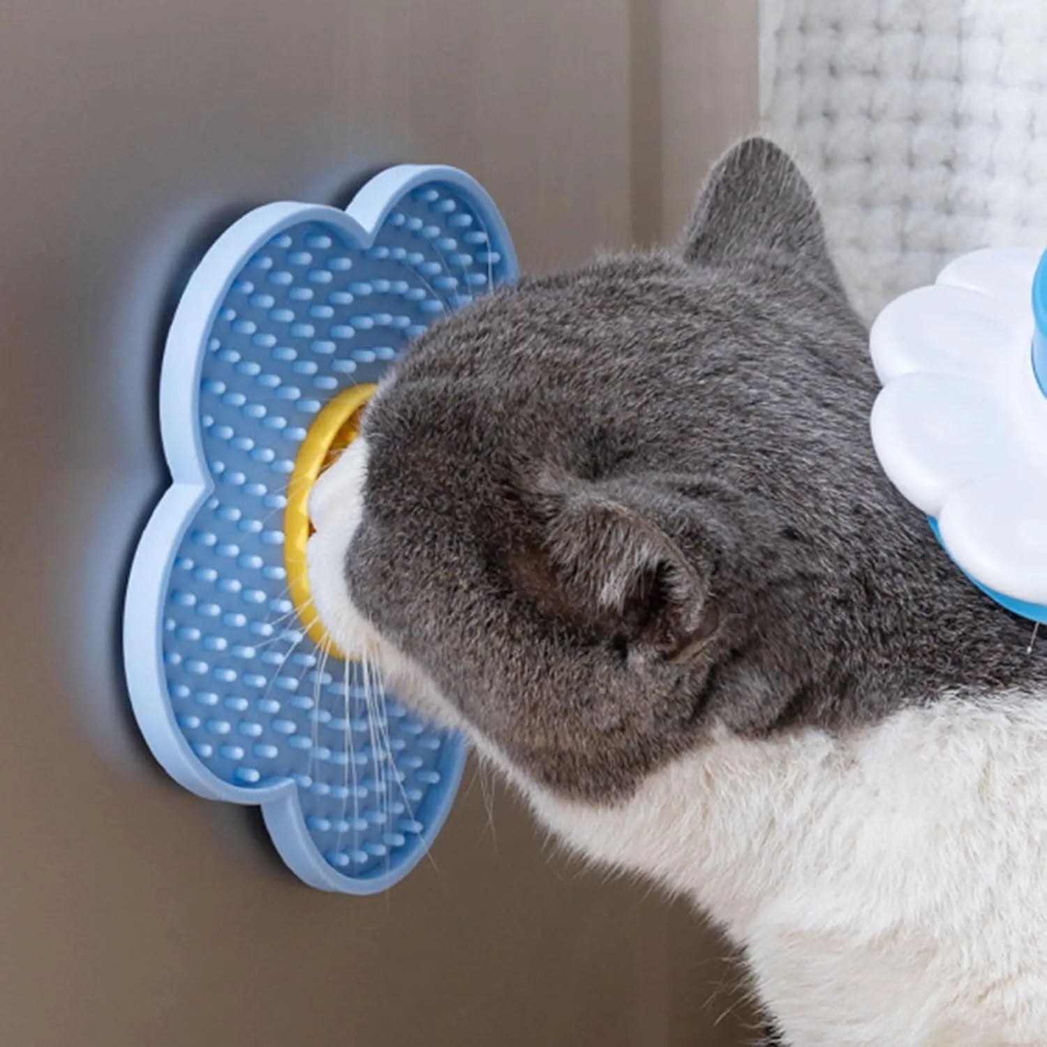 Flower-shaped silicone pet lick mat with suction cups on a smooth surface in assorted colours.