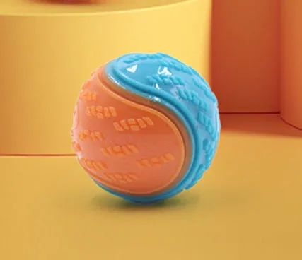 TPR dog training ball with squeaker in bright two-tone colours, showing molar texture on surface.