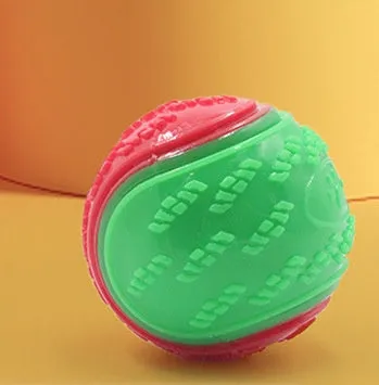 TPR dog training ball with squeaker in bright two-tone colours, showing molar texture on surface.