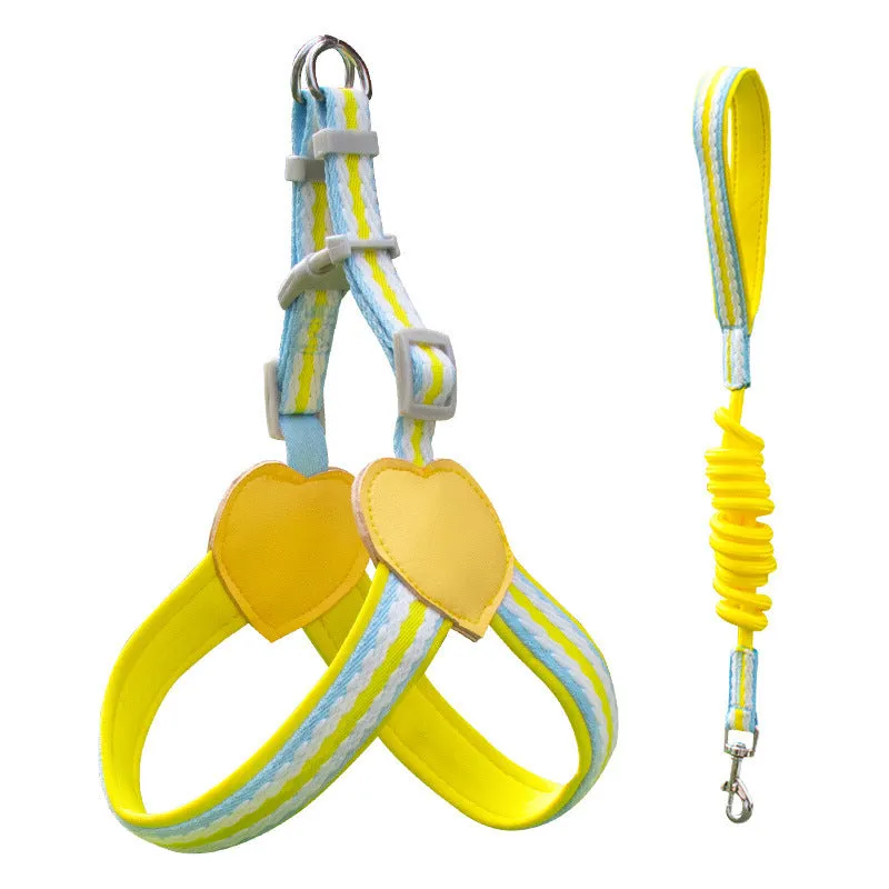 A dog wearing a pink nylon chest strap vest harness with an attached hand holding rope.