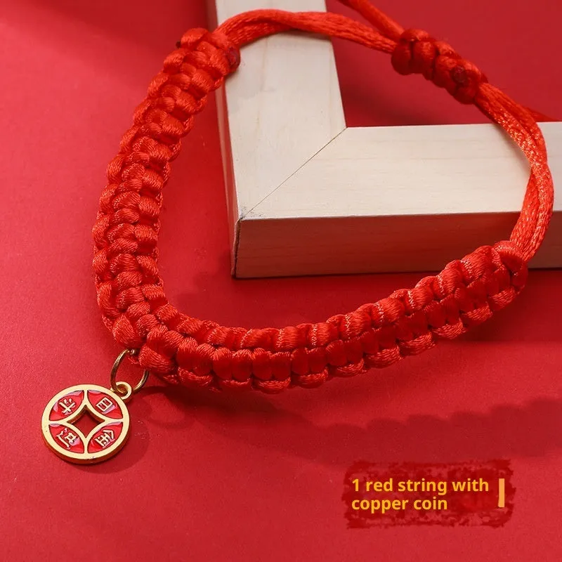Adjustable hand-woven red rope pet collar with alloy lucky charm on wooden surface