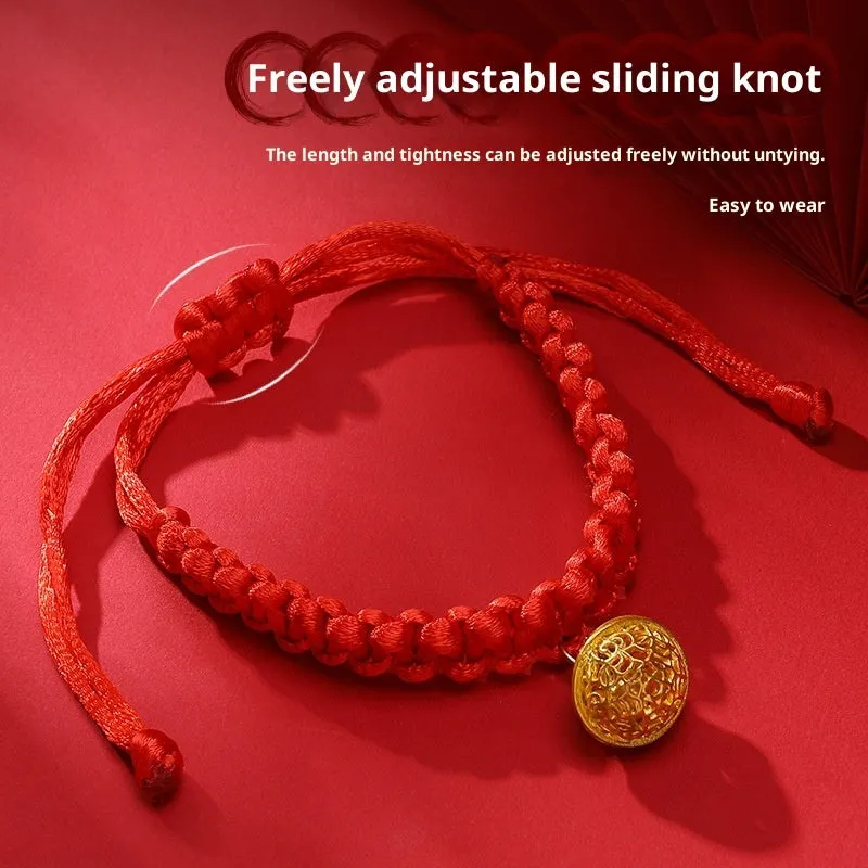 Adjustable hand-woven red rope pet collar with alloy lucky charm on wooden surface