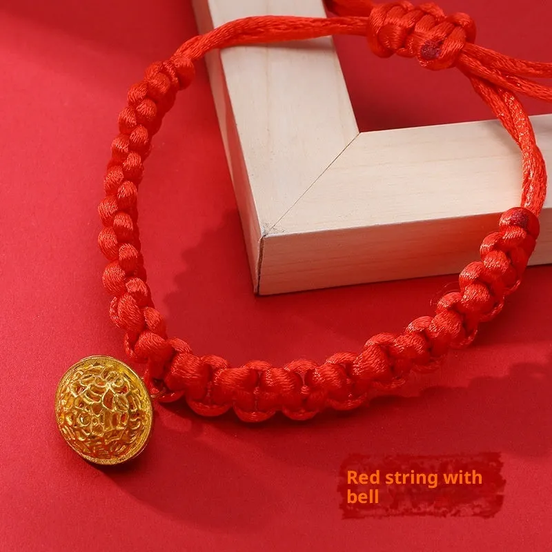 Adjustable hand-woven red rope pet collar with alloy lucky charm on wooden surface
