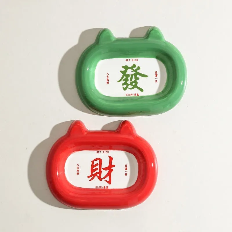 Glazed ceramic pet food bowl with animal design and non-slip rubber base ring.