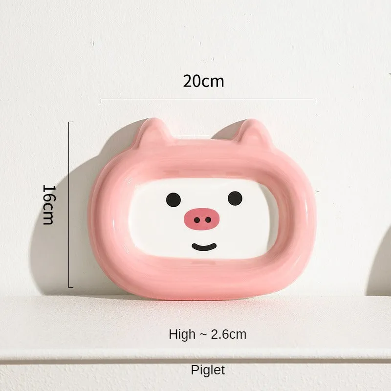Glazed ceramic pet food bowl with animal design and non-slip rubber base ring.