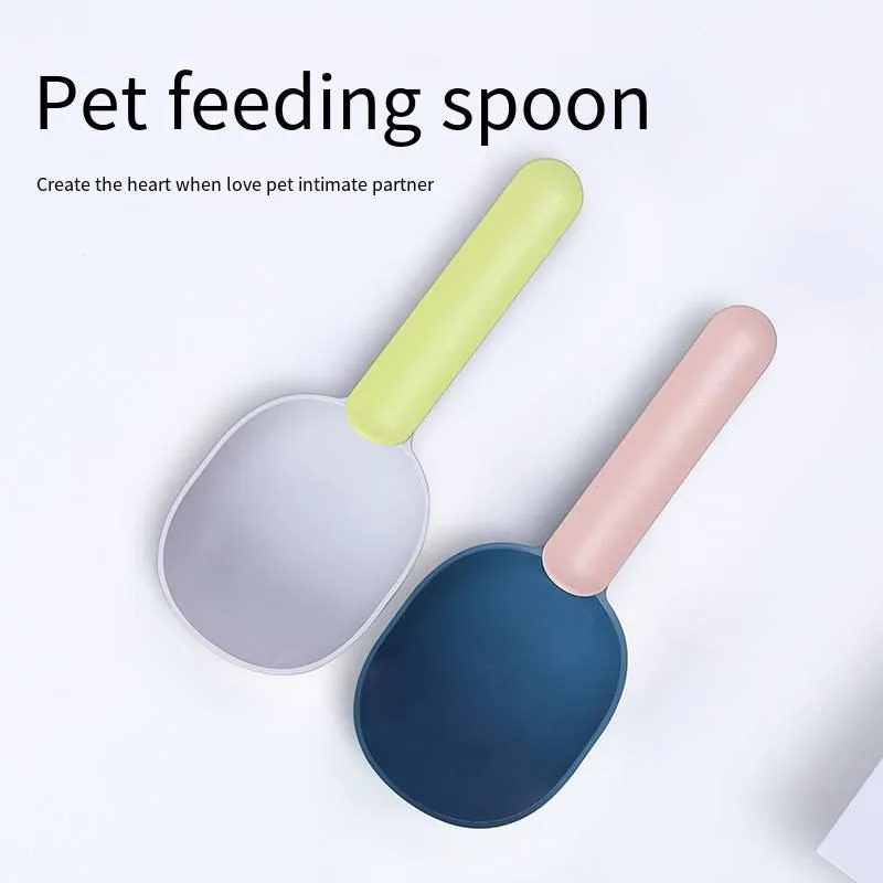 Blue plastic pet food scoop with ergonomic handle and bag clip on a white background