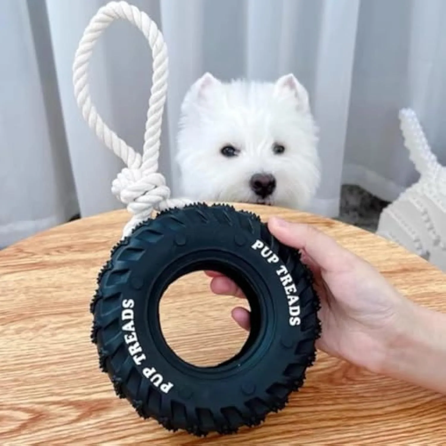 Tough natural rubber dog chew toy shaped like a tire with rope, black colour, for large dogs