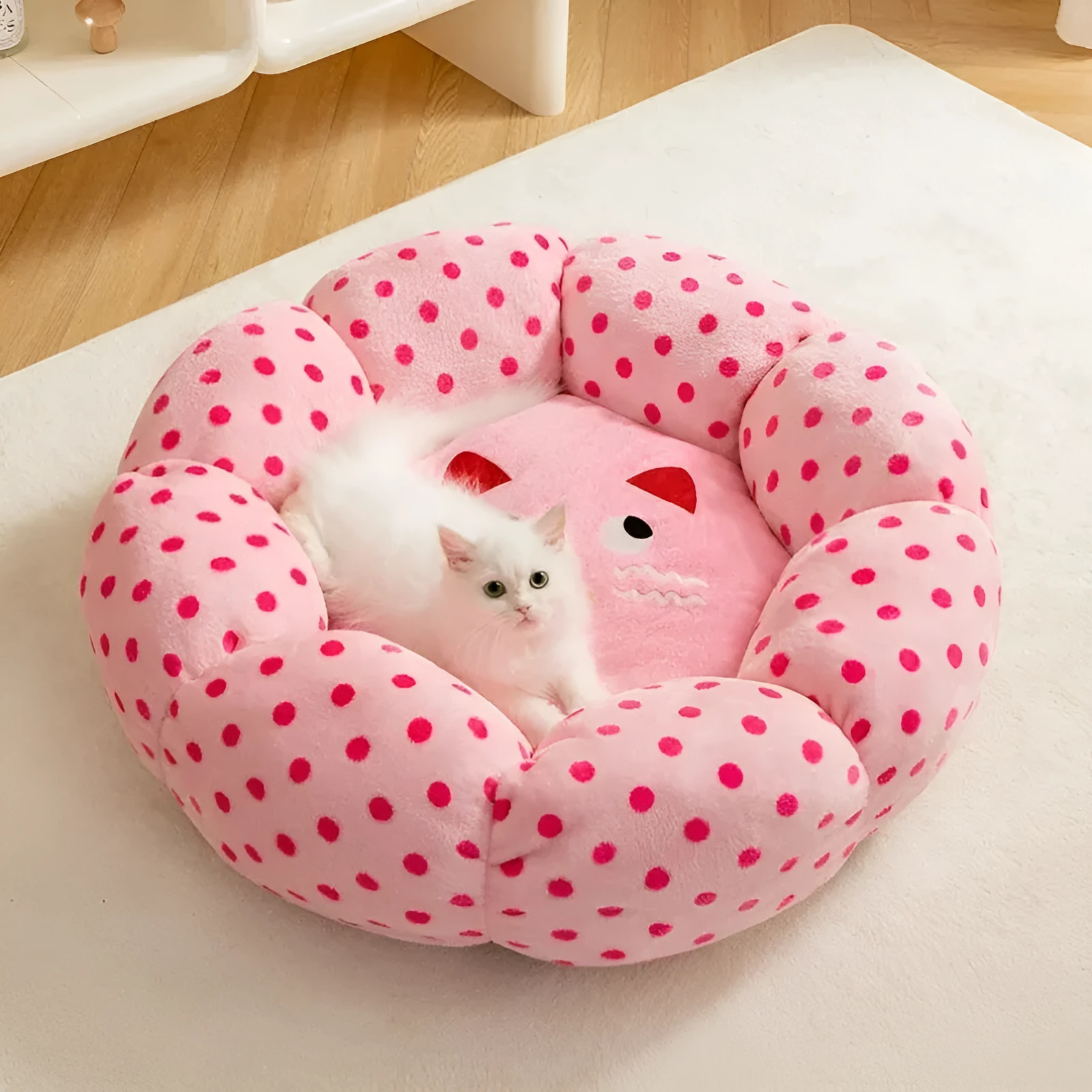Pink dot pattern fabric cat bed shown in two circular sizes, 45cm and 65cm diameter.