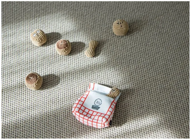 Hidden food toy set for dogs with two walnut toys, one peanut toy, and a rustling paper snack bag on a table
